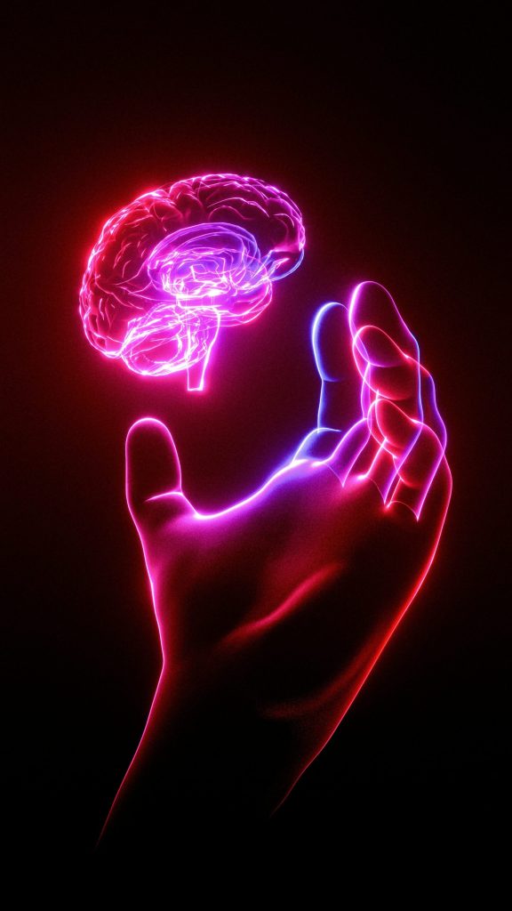 La main d'une personne tenant un modèle de cerveau lumineux.